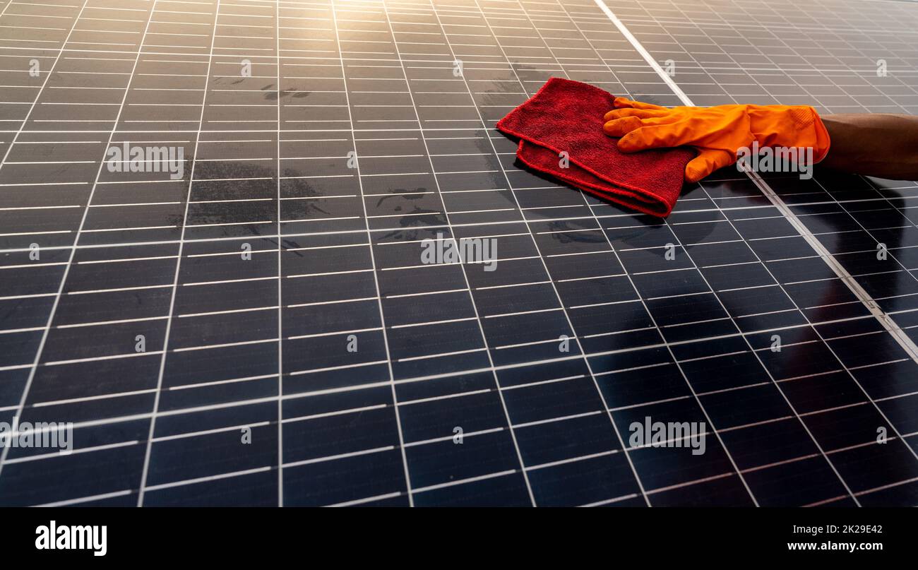 Reinigungsreiniger Solarpaneel auf dem Dach. Wartung von Sonnenkollektoren oder Photovoltaikmodulen. Nachhaltige Ressourcen und erneuerbare Energien für „Go Green“. Solarenergie für grüne Energie. Technologie für die Zukunft. Stockfoto