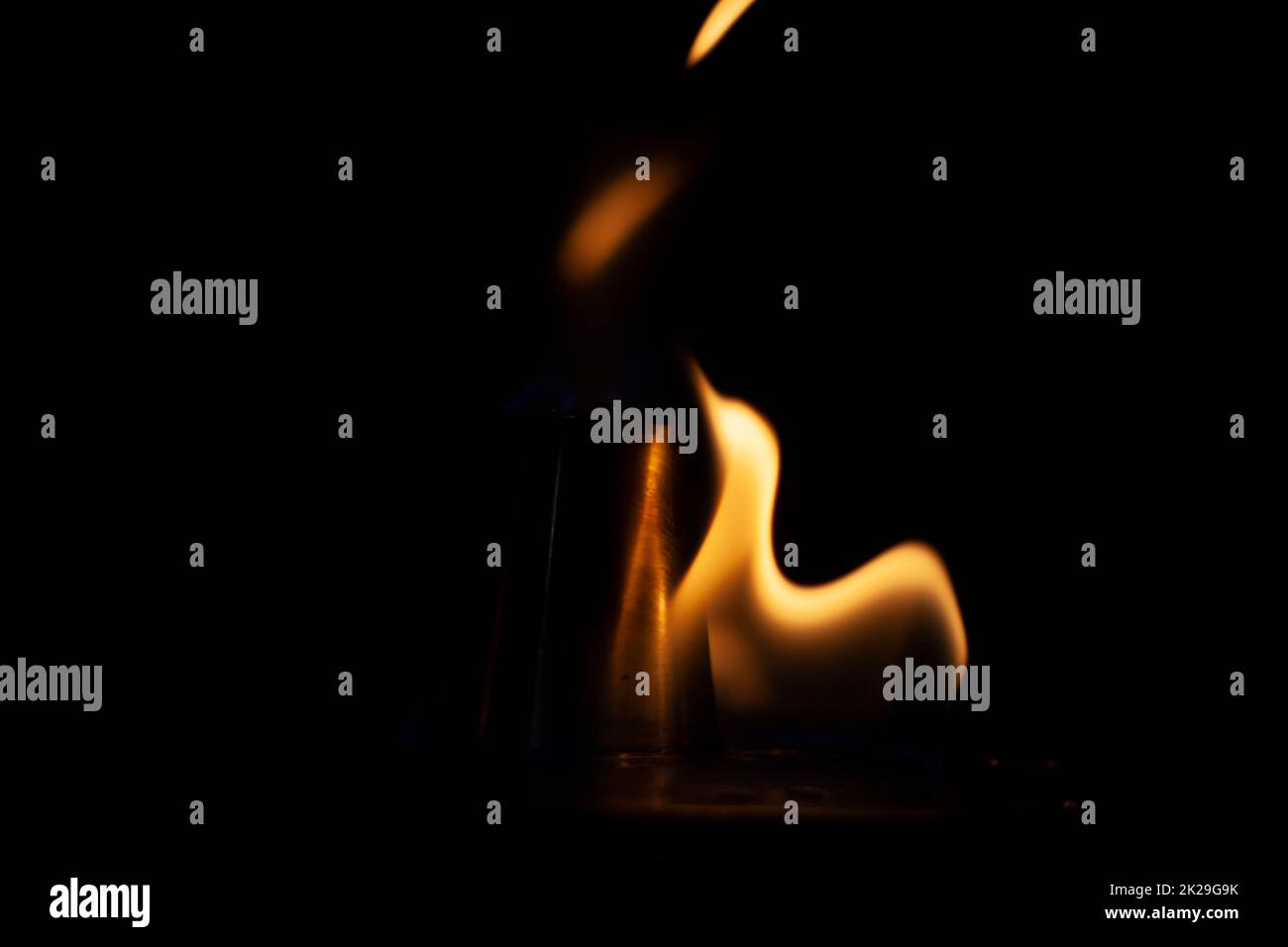 Flammen im Dunkeln. Feuer ist gelb auf schwarzem Hintergrund. Stockfoto