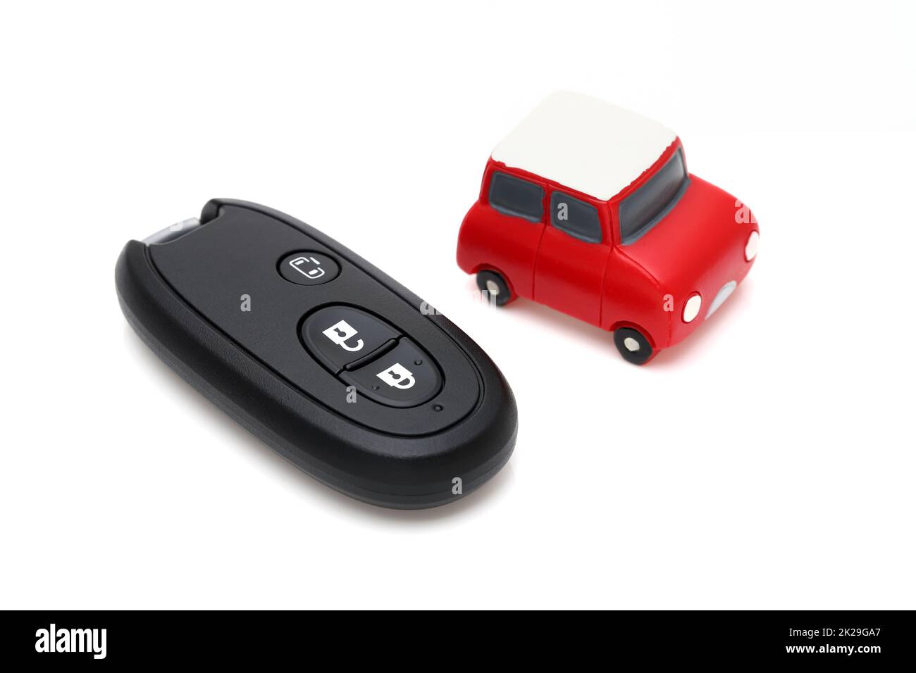 Auto schwarzen Schlüssel Fernbedienung und kleine Spielzeugauto auf weißem Hintergrund Stockfoto