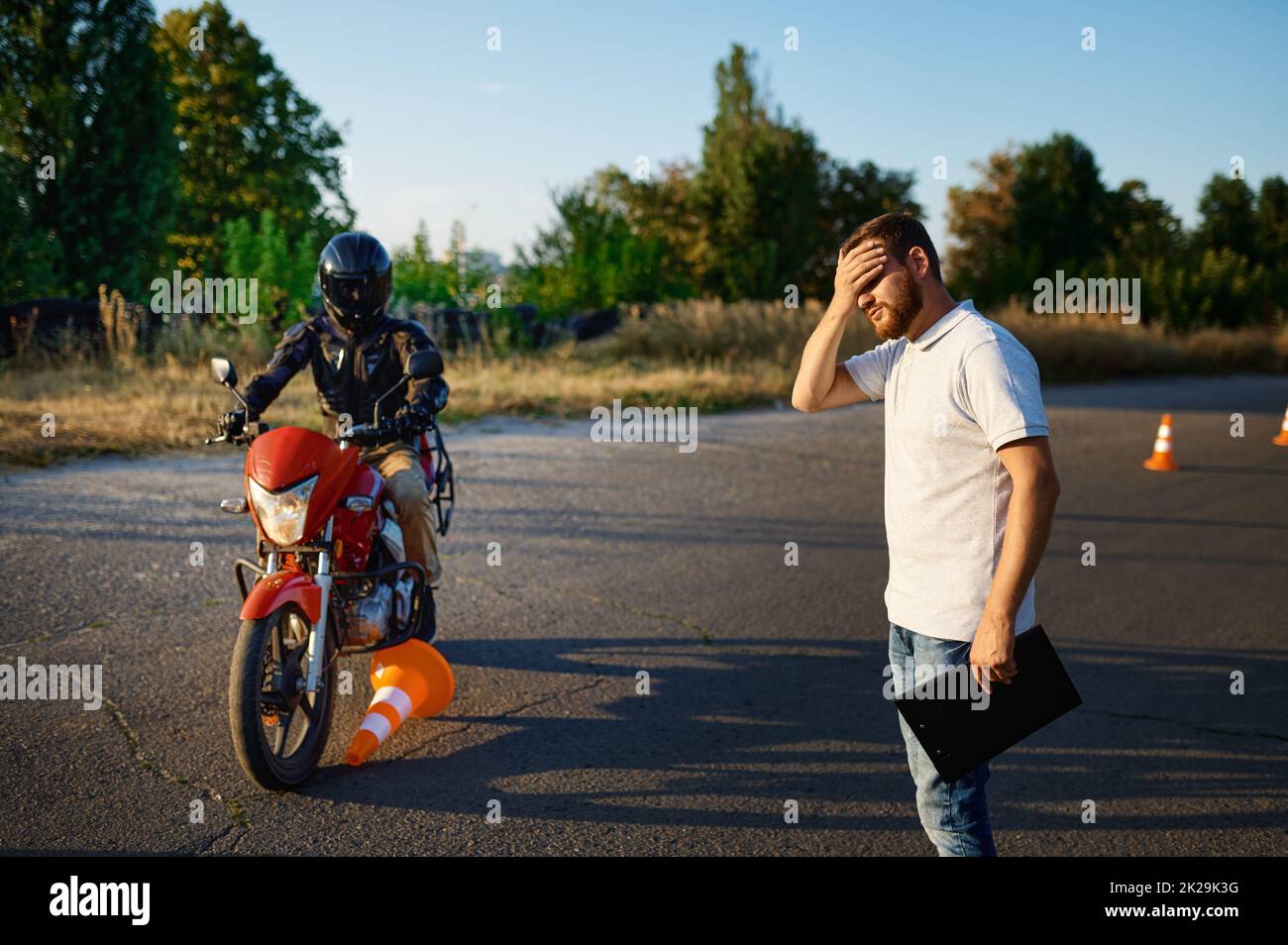 Männlicher Student auf dem Motorrad lief über einen Kegel Stockfoto