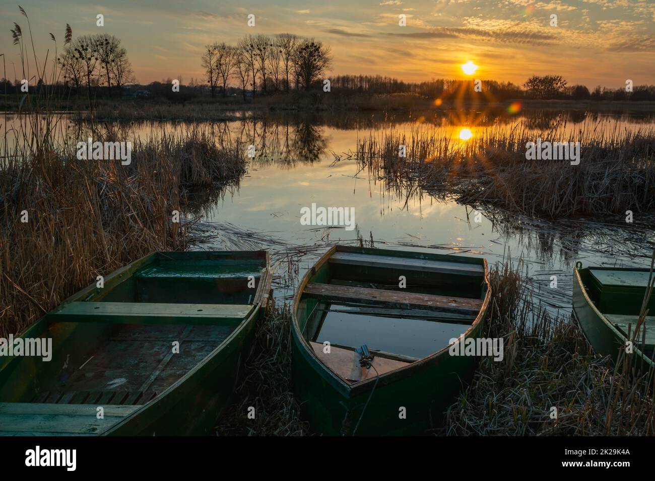 Boote am Ufer des Sees und Sonnenuntergang Stockfoto