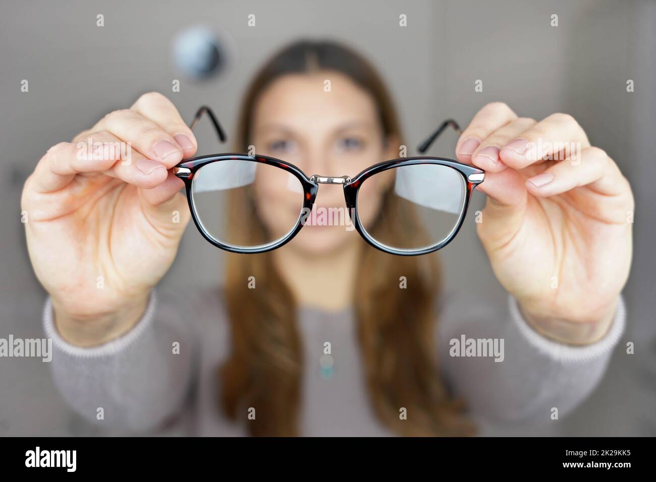 Schlechtes Sehvermögen. Mädchen hält Brille zum Sehen in ihren Händen. Stockfoto