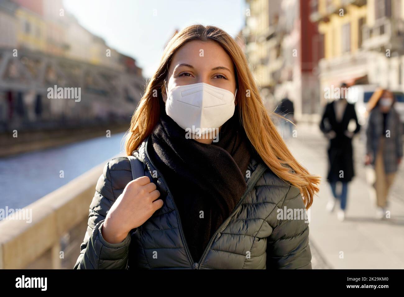 Beauty Mode Mädchen tragen schützende Gesichtsmaske zu Fuß in der Stadt Straße bei Sonnenuntergang Stockfoto