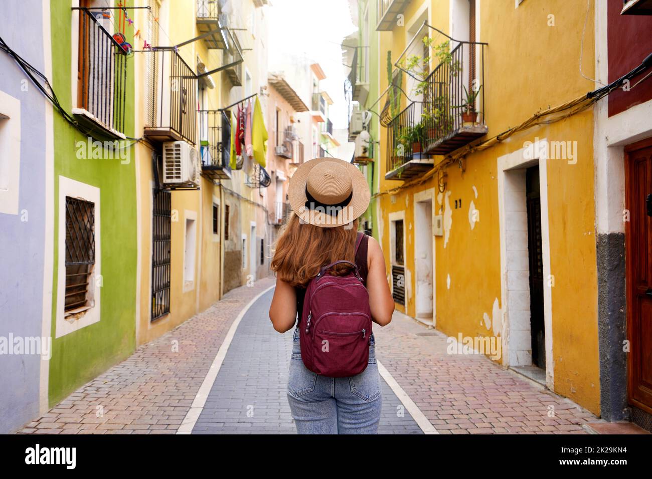 Reisen in Europa. Fröhliches Touristenmädchen, das das bunte spanische Dorf Villajoyosa, Alicante, Spanien besucht. Stockfoto