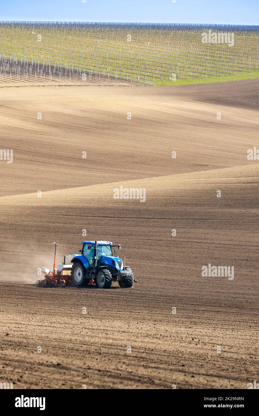 Traktor mit Saatbohrer in der frühen Frühlingslandschaft Stockfoto