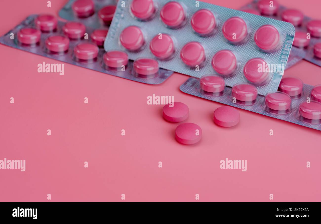 Rosafarbene Tablettentabletten und Blisterpackung mit Tabletten auf pinkfarbenem Hintergrund. Verschreibungspflichtige Medikamente. Konzept für Vitamine, Mineralstoffe und Nahrungsergänzungsmittel. Pharmazeutische Industrie. Gesundheitswesen und Medizin. Pharmazeutisches Produkt. Stockfoto