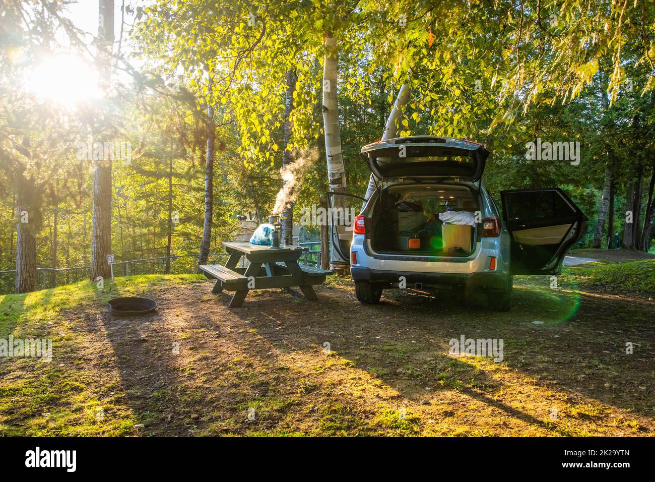 Sonniger Morgen Kochen und Camping im Freien mit Auto auf dem Campingplatz Stockfoto