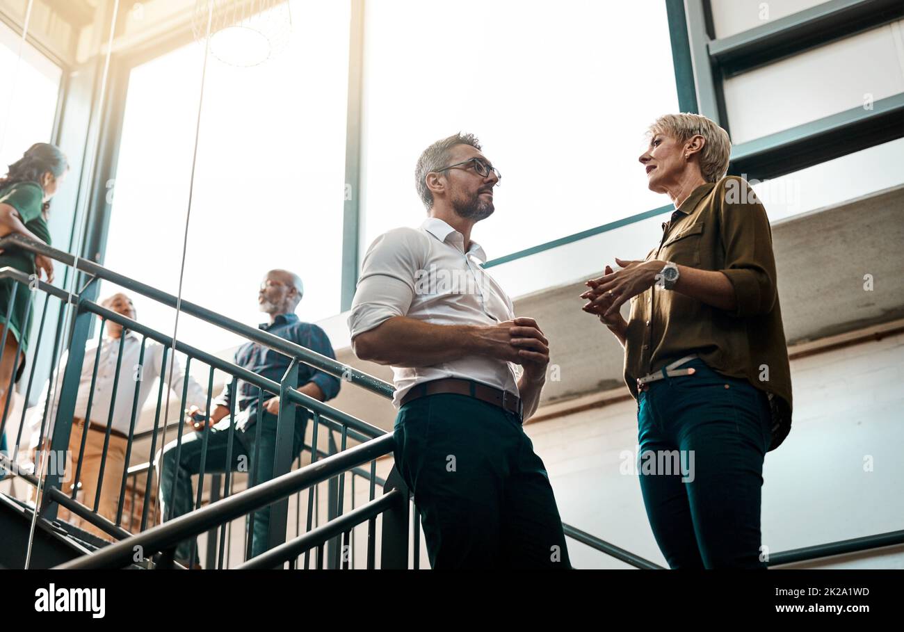 Gute Ideen kommen aus lockeren Gesprächen. Aufnahme von zwei Geschäftsleuten, die sich auf einem Treppenhaus unterhalten. Stockfoto