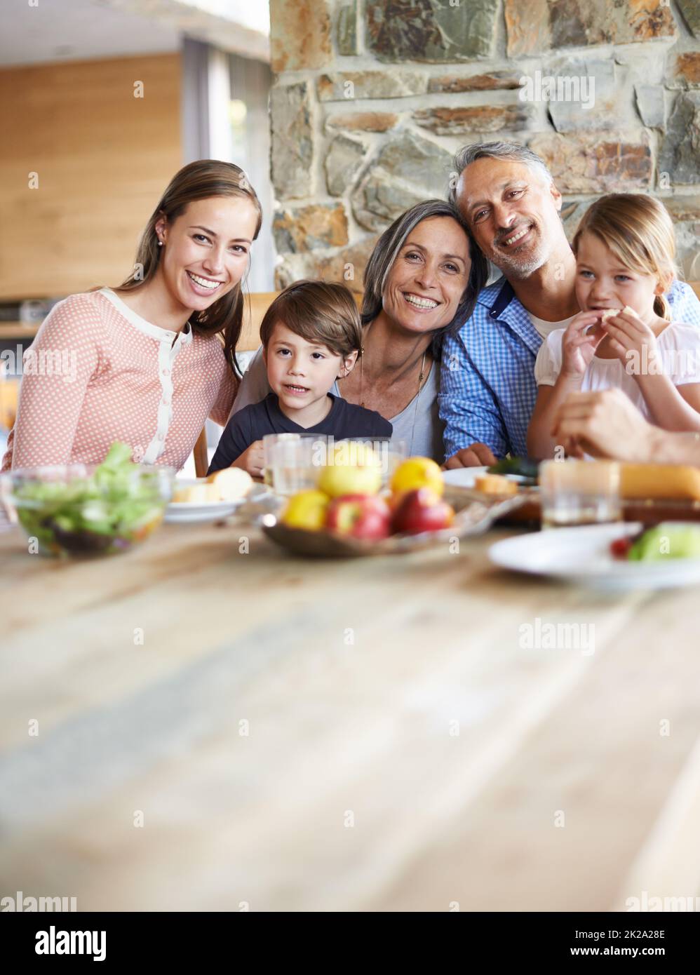 Wertvolle Momente mit den Enkelkindern. Ein Porträt einer glücklichen, generationsübergreifenden Familie, die an einem Tisch sitzt und zusammen zu Mittag gegessen hat. Stockfoto