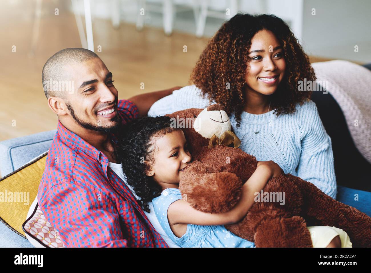 Familienzeit ist Glückszeit. Eine Aufnahme einer glücklichen, jungen Familie von drei Kindern, die sich zu Hause in ihrem Wohnzimmer entspannen. Stockfoto