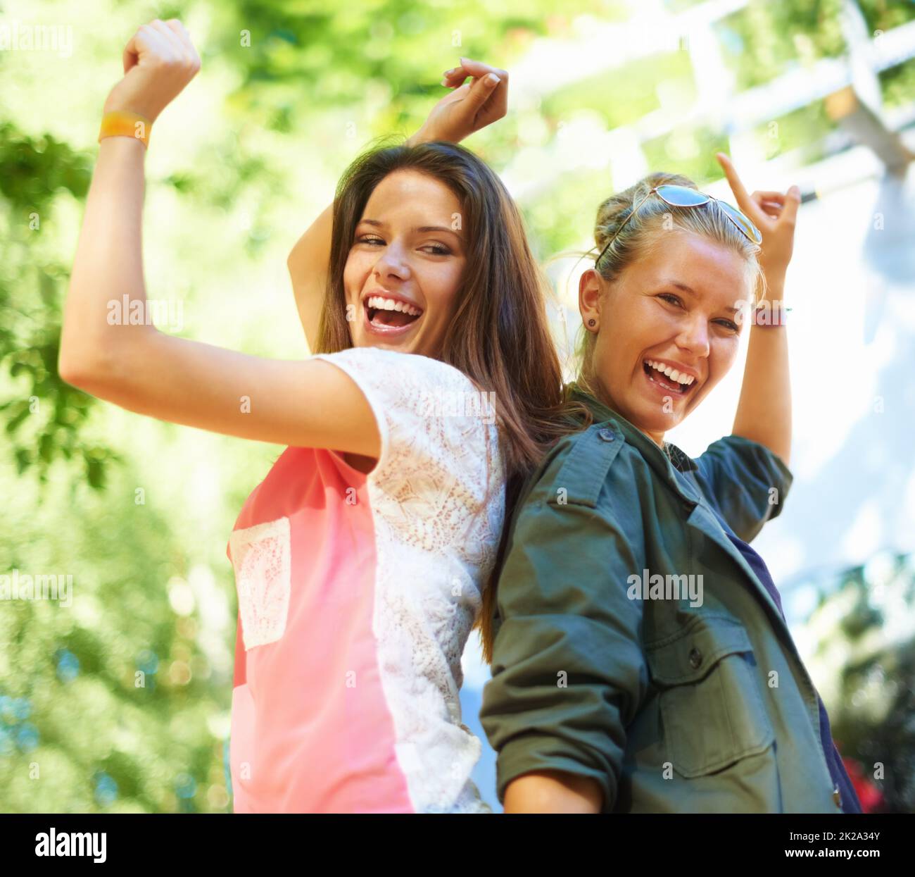 Tanzen zum Takt ihrer eigenen Trommel. Zwei fröhliche junge Frauen, die draußen tanzen. Stockfoto