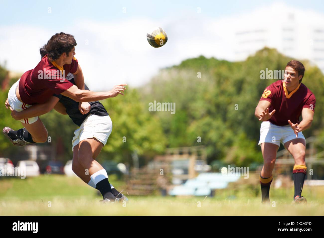 Gemeinsam für eine stärkere Einheit arbeiten. Aufnahme eines jungen Rugby-Spielers, der mitten im Tackle einen Pass ausführt. Stockfoto