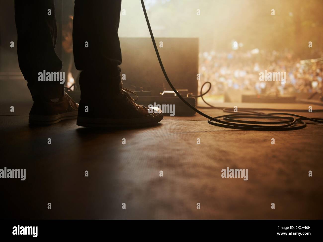 Bereit zum Rocken. Eine kurze Aufnahme eines Musikers, der auf der Bühne eines Musikfestivals im Freien steht. Stockfoto