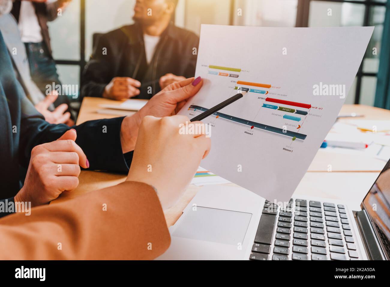 Eine Gruppe von Geschäftsleuten trifft sich über Unternehmensstatistiken Stockfoto