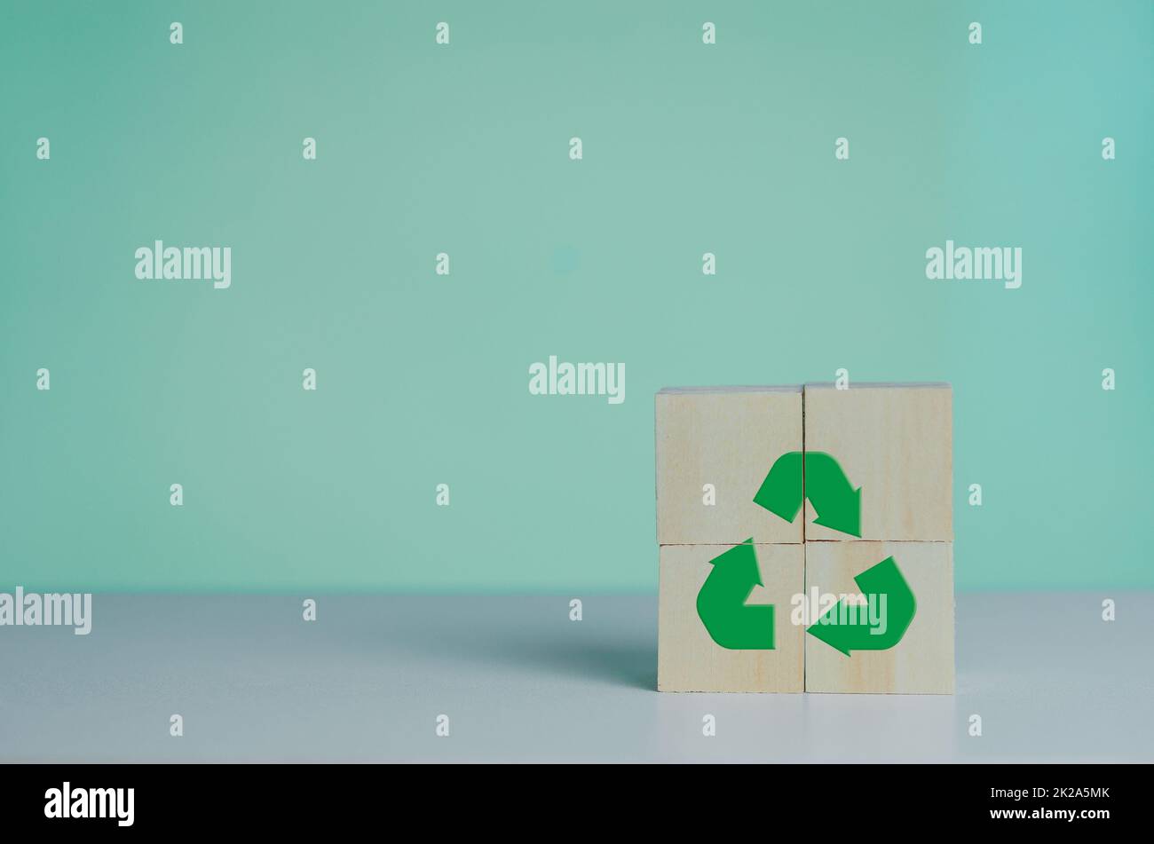 Holzwürfel mit Recycling-Symbol und grüne Industrie. Umweltfreundliches Geschäfts- und Entwicklungskonzept im Hintergrund. Stockfoto