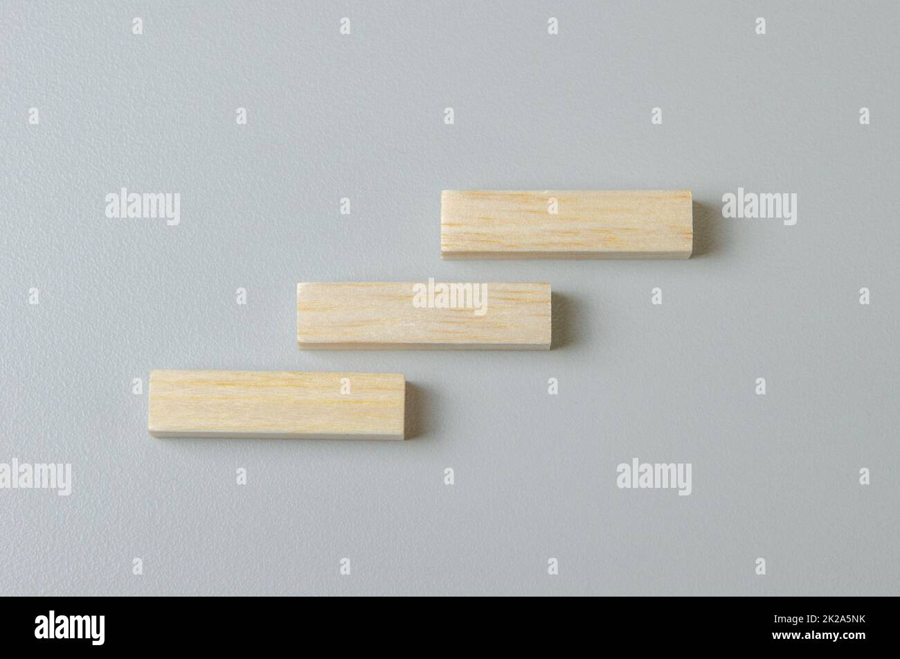 Leerer Holzblock für Symbole oder Symbole auf grauem Hintergrund. Stockfoto