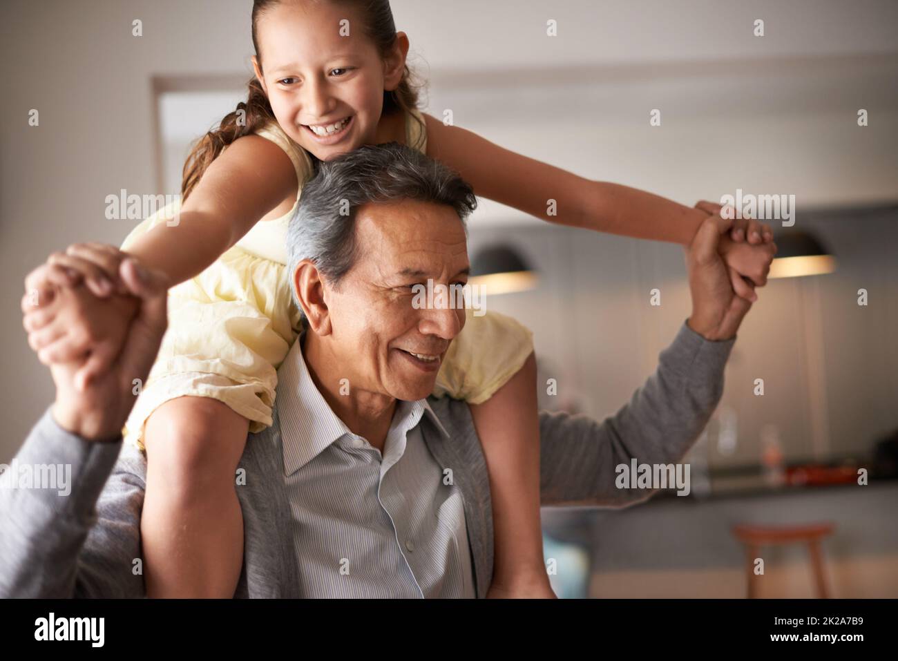 Opa macht so viel Spaß. Aufnahme eines Großvaters, der seiner kleinen Enkelin ein Schweinchen zurückgab. Stockfoto