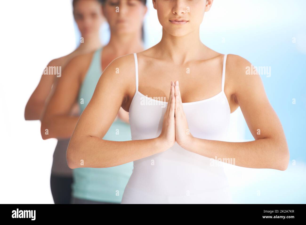Ruhe und Gelassenheit suchen. Gruppe von ruhigen Yoga-Praktizierenden, die zusammen meditieren - abgeschnitten. Stockfoto