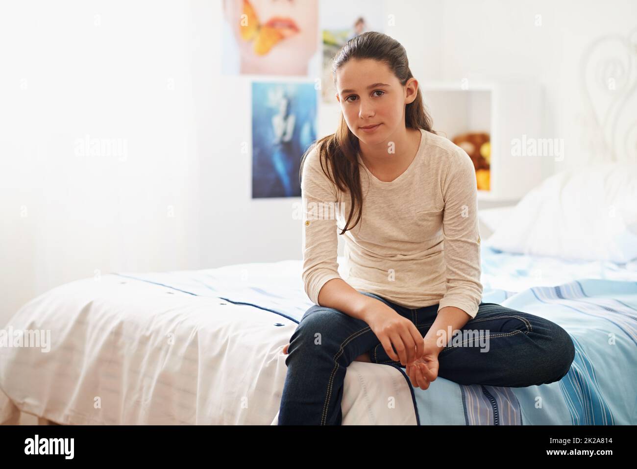 Ein Tag im Leben eines Teenagers. Porträt eines Teenagers, das zu Hause auf ihrem Bett sitzt. Stockfoto