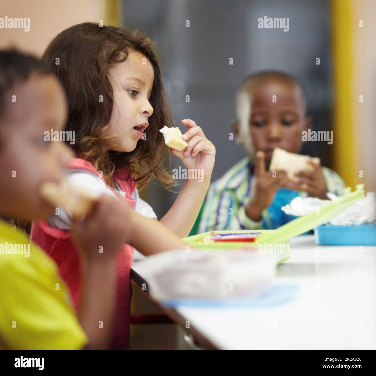 Pausenzeit. Drei Kinder essen ihre Sandwiches zum Mittagessen. Stockfoto