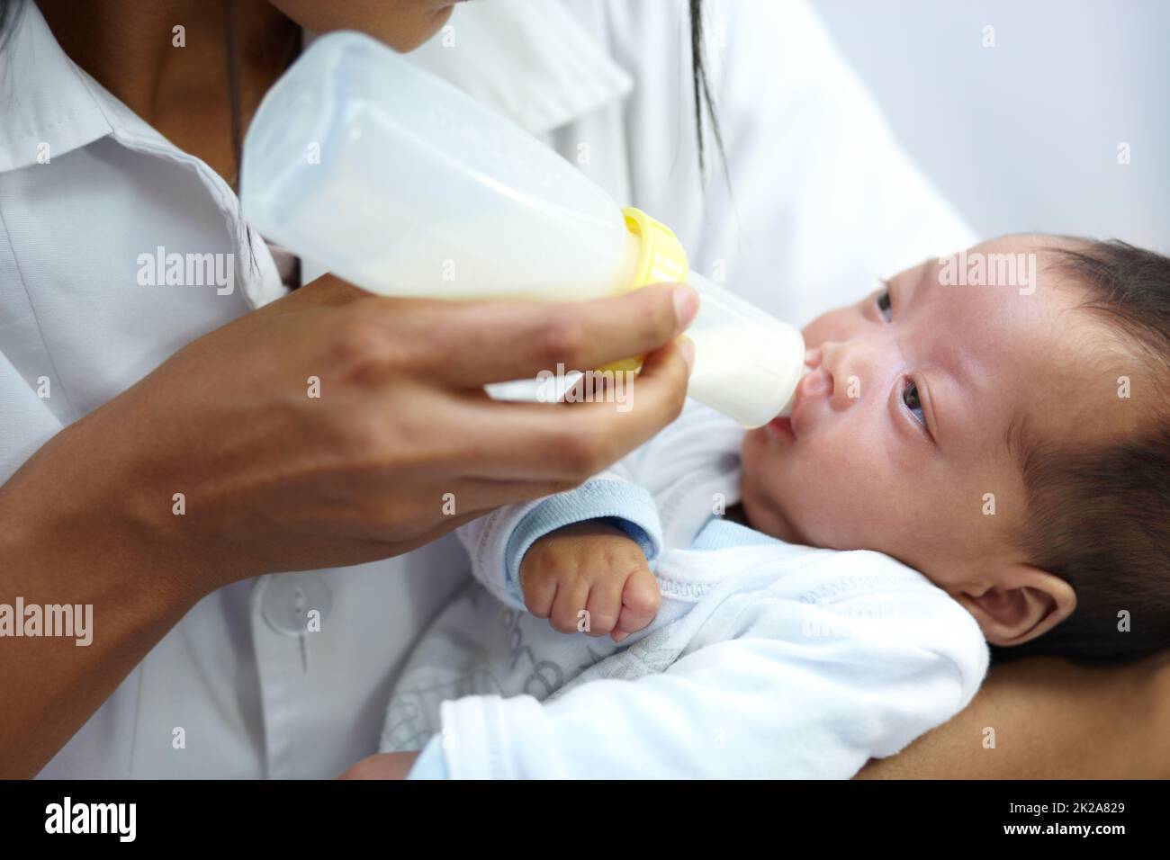 Die Fütterungszeit. Aufnahme eines Arztes, der einem Säugling mit Gaumenspalte eine Formel gibt. Stockfoto