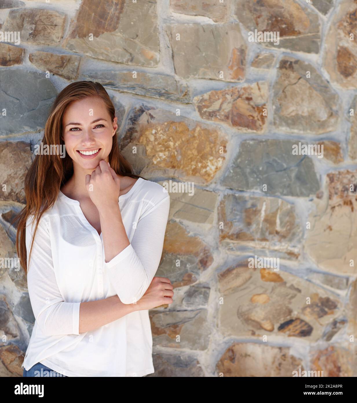 Sie hatte keine Sorge in der Welt. Eine hübsche junge Frau, die an einem sonnigen Tag draußen steht. Stockfoto