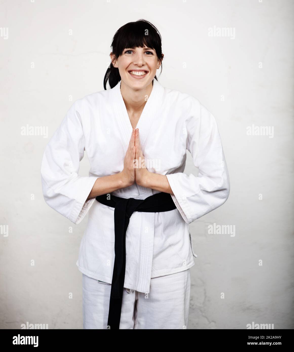 Master of the Martial Arts. Studioportrait einer jungen Frau, die sich in ihrem Karate gi beugt. Stockfoto