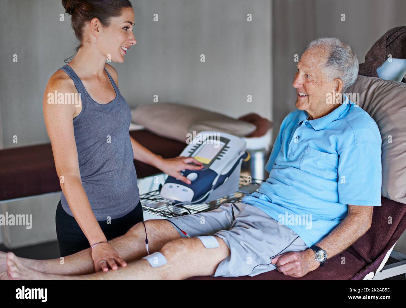 Ein älterer Mann, der eine Physiotherapie mit einer Therapeutin hat. Stockfoto