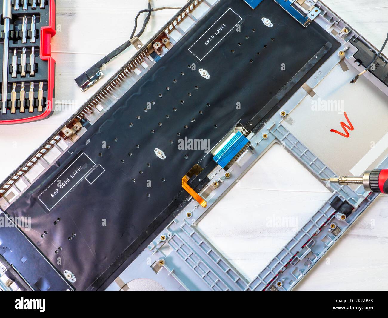 Reparatur und Wartung von Computer-Laptop, Laptop-Deckel demontiert und Schraubendreher oben hängen. Stockfoto