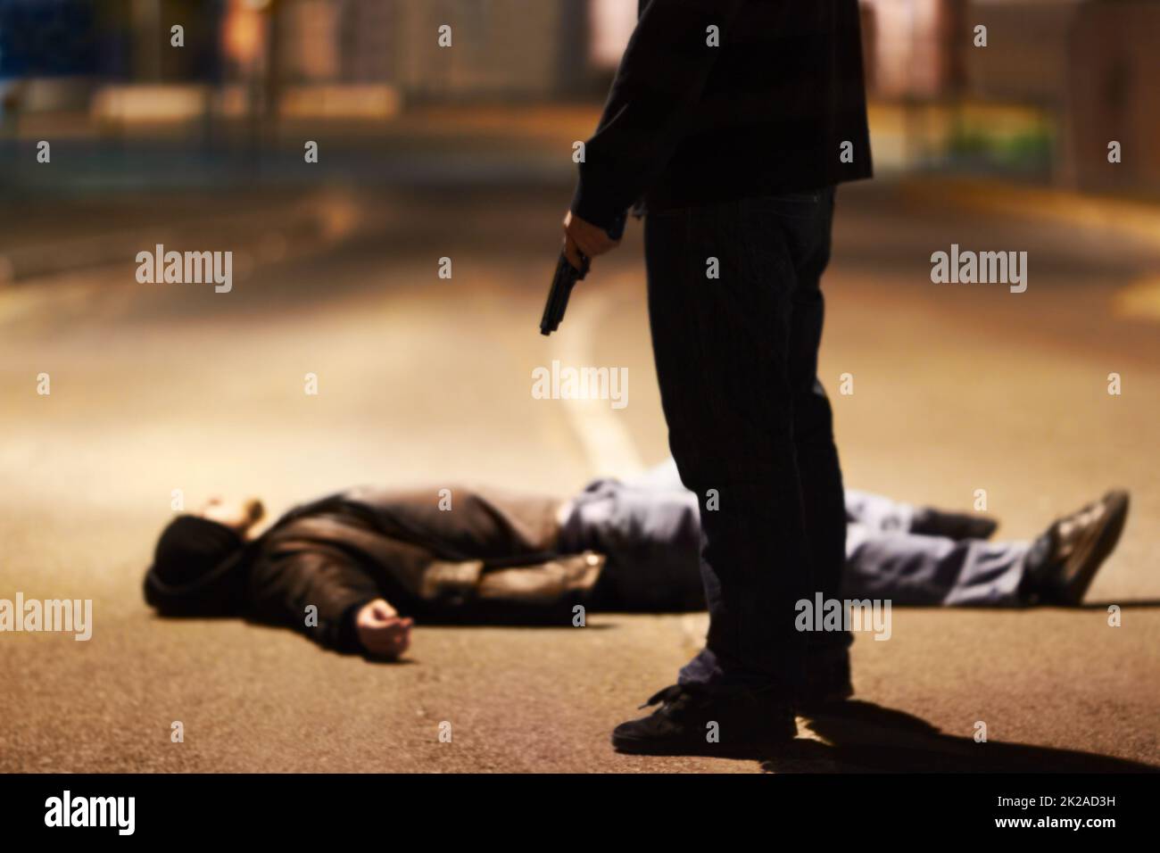 Gewaltakte. Mann, der auf dem Boden liegt, nachdem er von einem mit Waffen schwingenden Verbrecher geschossen wurde. Stockfoto