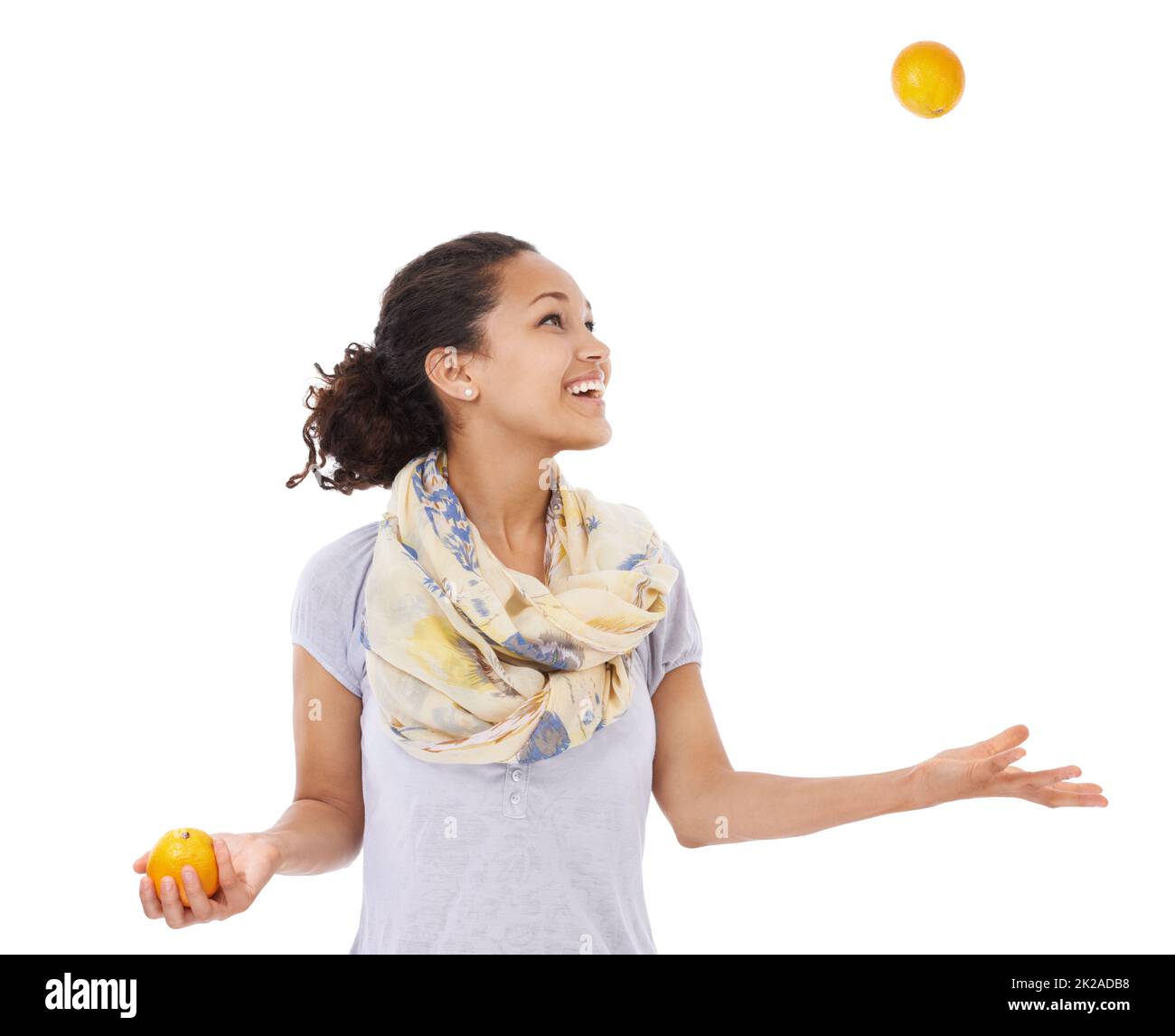 Shes hat ihr Auge auf die Balance einer gesunden Ernährung. Junge Frau lächelt, während sie mit frischen Orangen jongliert. Stockfoto