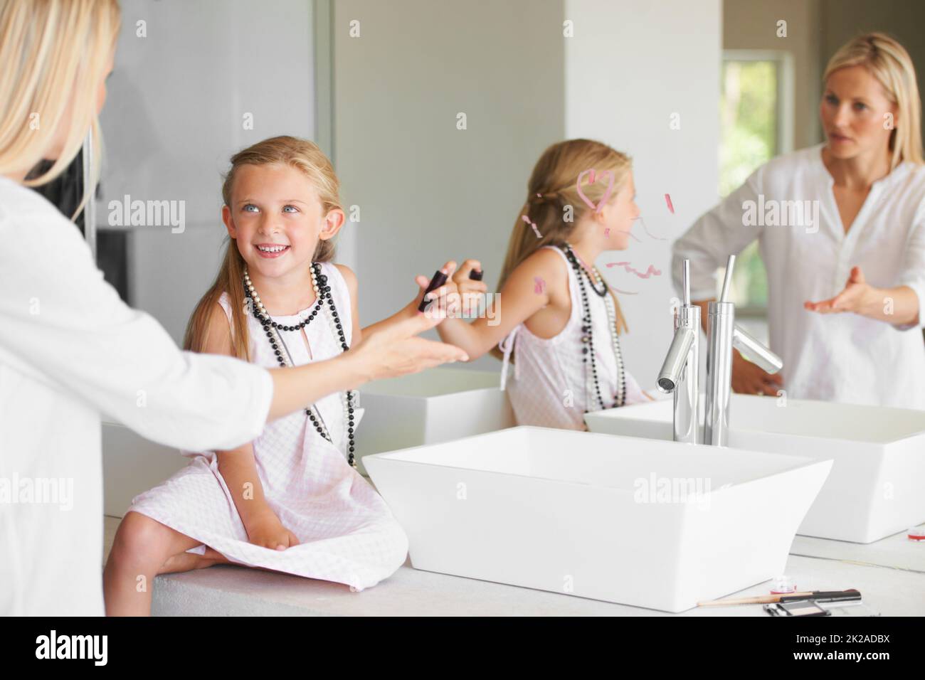 Warum habt Ihr das getan? Kleines Mädchen im Badezimmer in Schwierigkeiten für das Zeichnen auf den Spiegel. Stockfoto