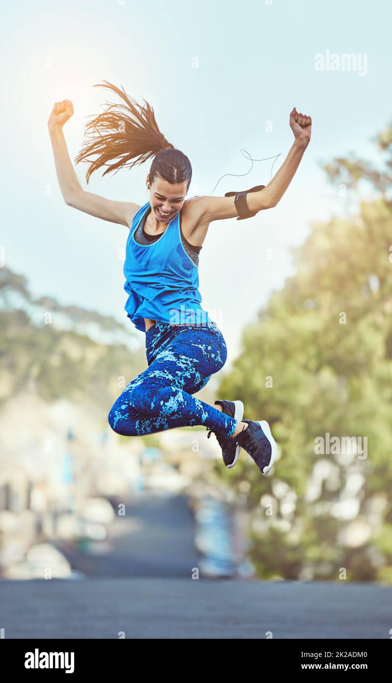 Harte Arbeit bleibt nie unbemerkt. Aufnahme einer jungen Frau, die nach dem Training in der Luft springt. Stockfoto