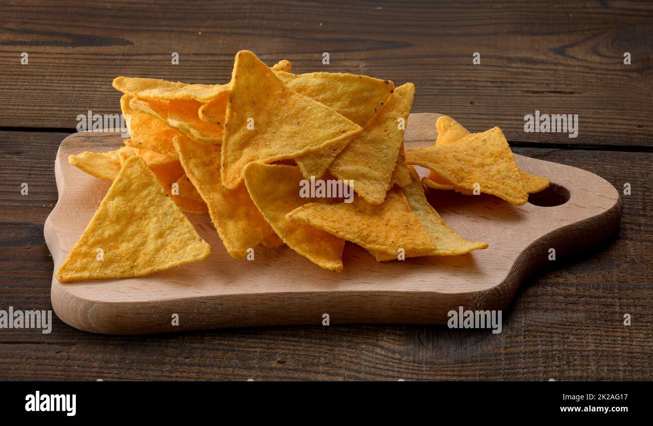 Ein Haufen Tortilla-Chips oder Nachos auf braunem Holzhintergrund Stockfoto