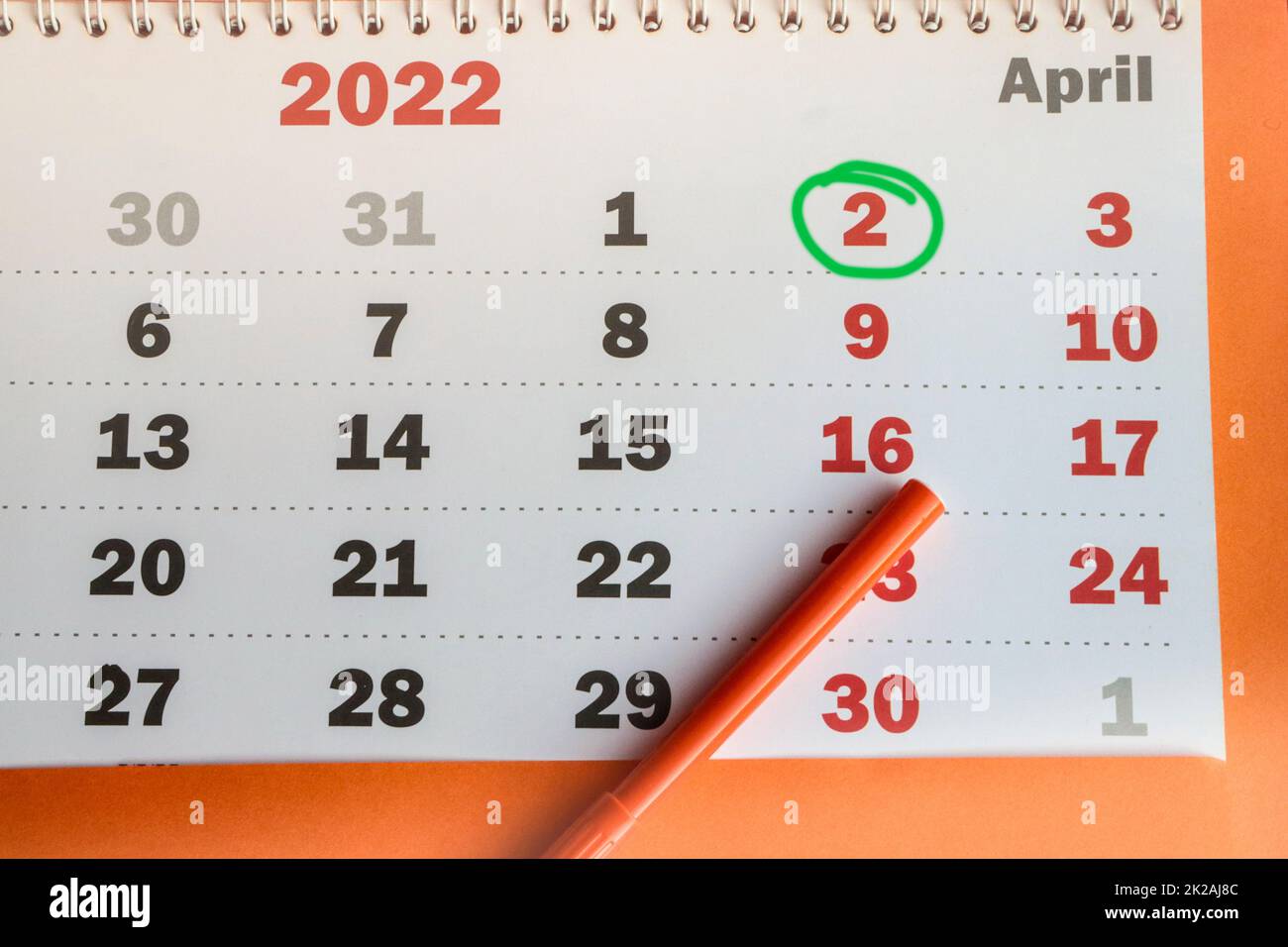 International Children's Book Day, an der Wand montierter Kalender aus Papier mit einem hervorgehobenen Datum vom 02. April 2022 und einem orangefarbenen Marker, Draufsicht Stockfoto