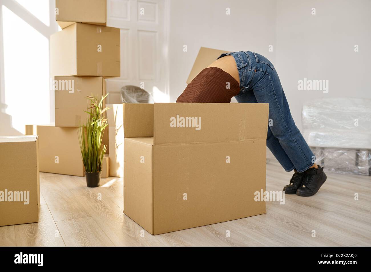 Lustige Frau, die etwas in einem großen Kasten sieht Stockfoto