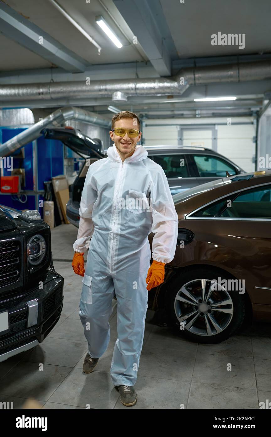 Junger zufriedener Lackmeister in der Autogarage Stockfoto