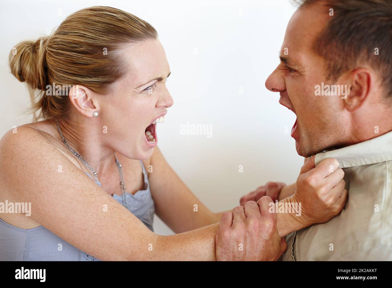ID lieber geliebt und verloren haben. Nahaufnahme einer Frau, die sich vor Wut das Hemd ihres Mannes schnappt, während sie kämpfen. Stockfoto