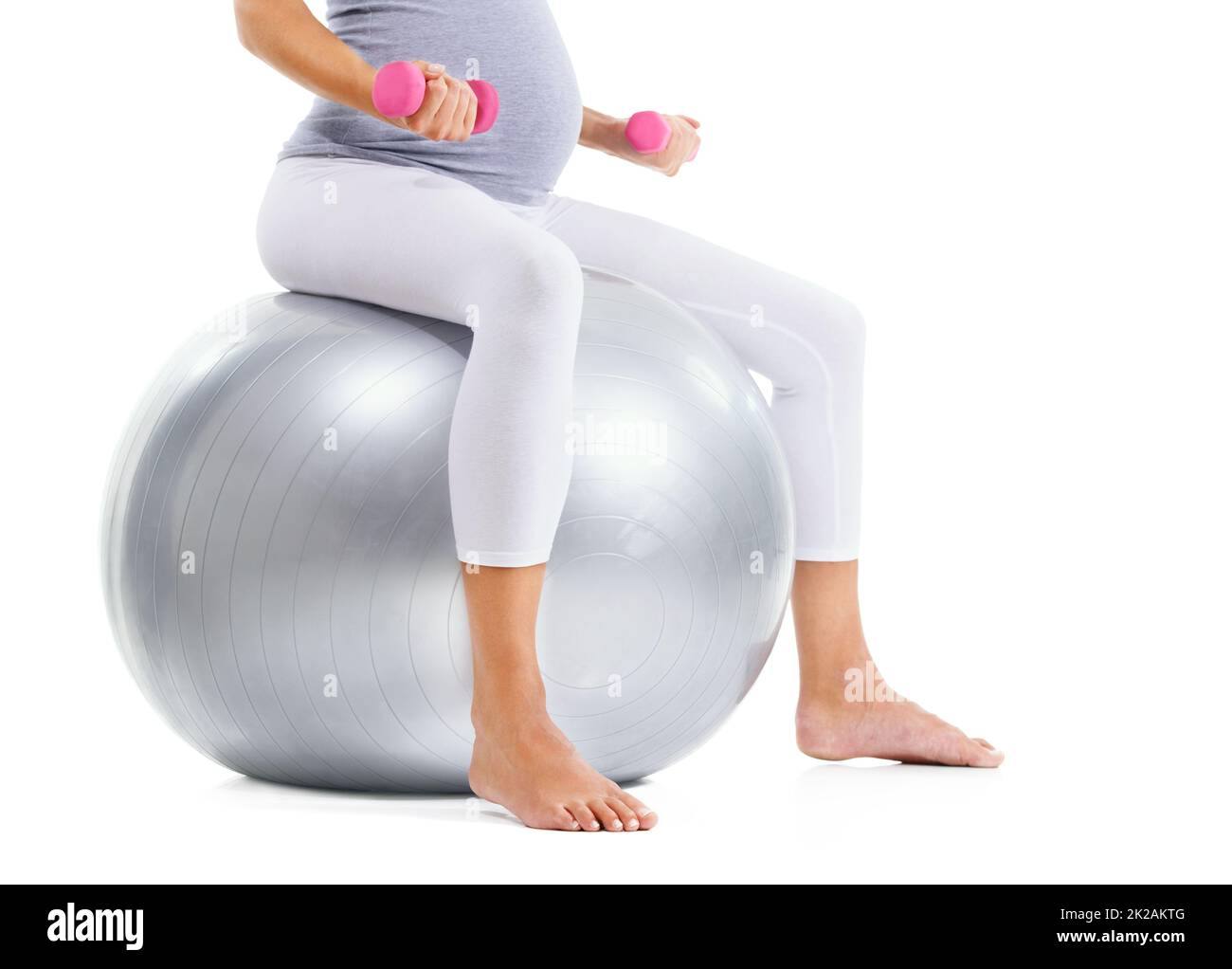 Aufrechterhaltung ihrer Fitness. Zugeschnittenes Bild einer Frau, die mit einem Übungsball und leichten Gewichten trainiert. Stockfoto