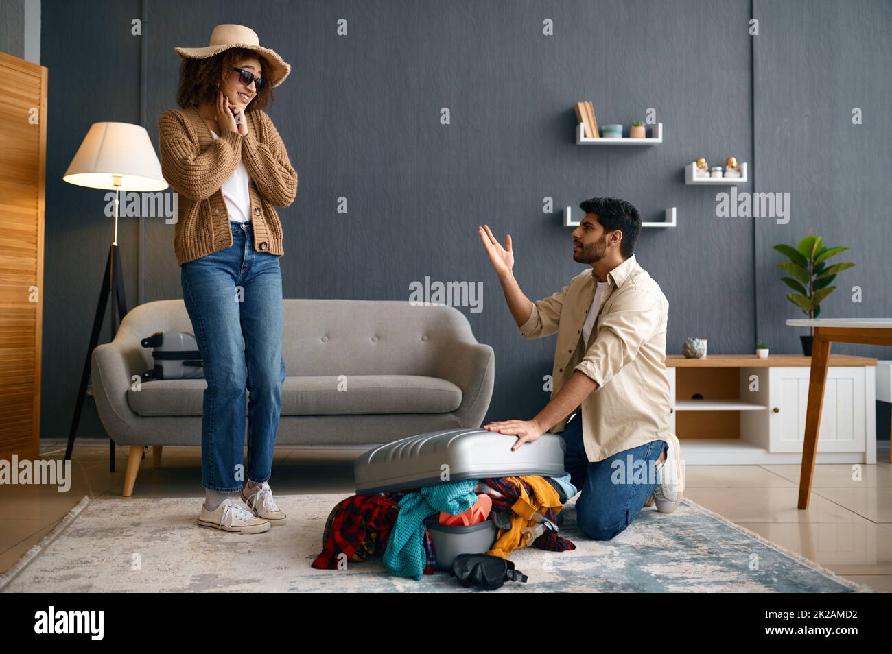 Multirassisches Paar, das Kleidung in Reisekoffer verpackt Stockfoto