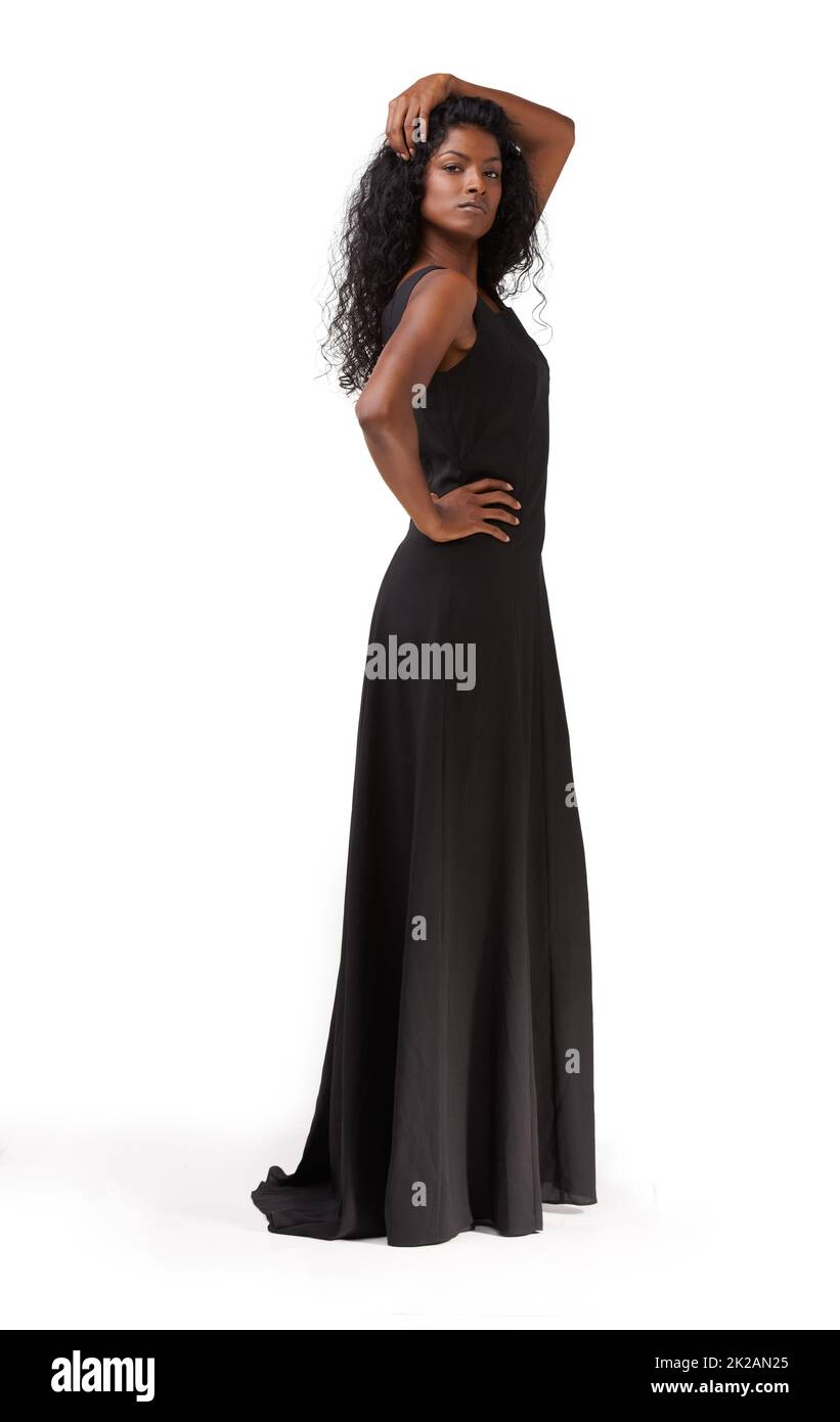 Dunkle Schönheit. Eine schöne ethnische Frau, die in einem langen schwarzen Kleid steht. Stockfoto