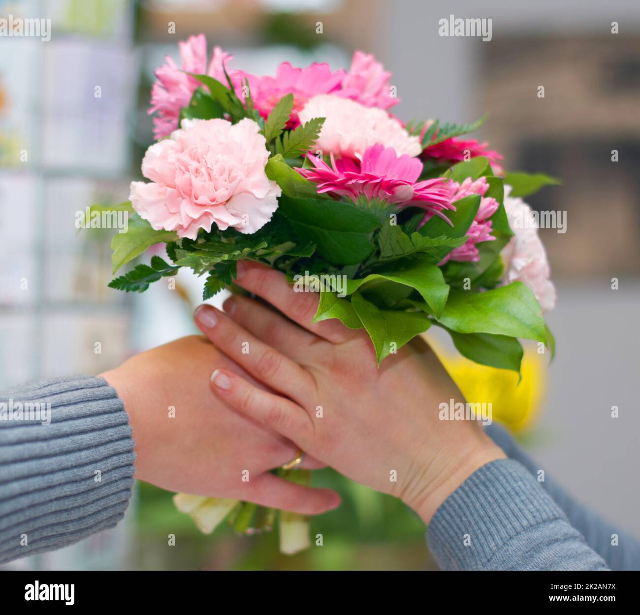 Vielen Dank. Zugeschnittene Aufnahme eines Blumenstrausses, der jemandem ausgehändigt wird. Stockfoto