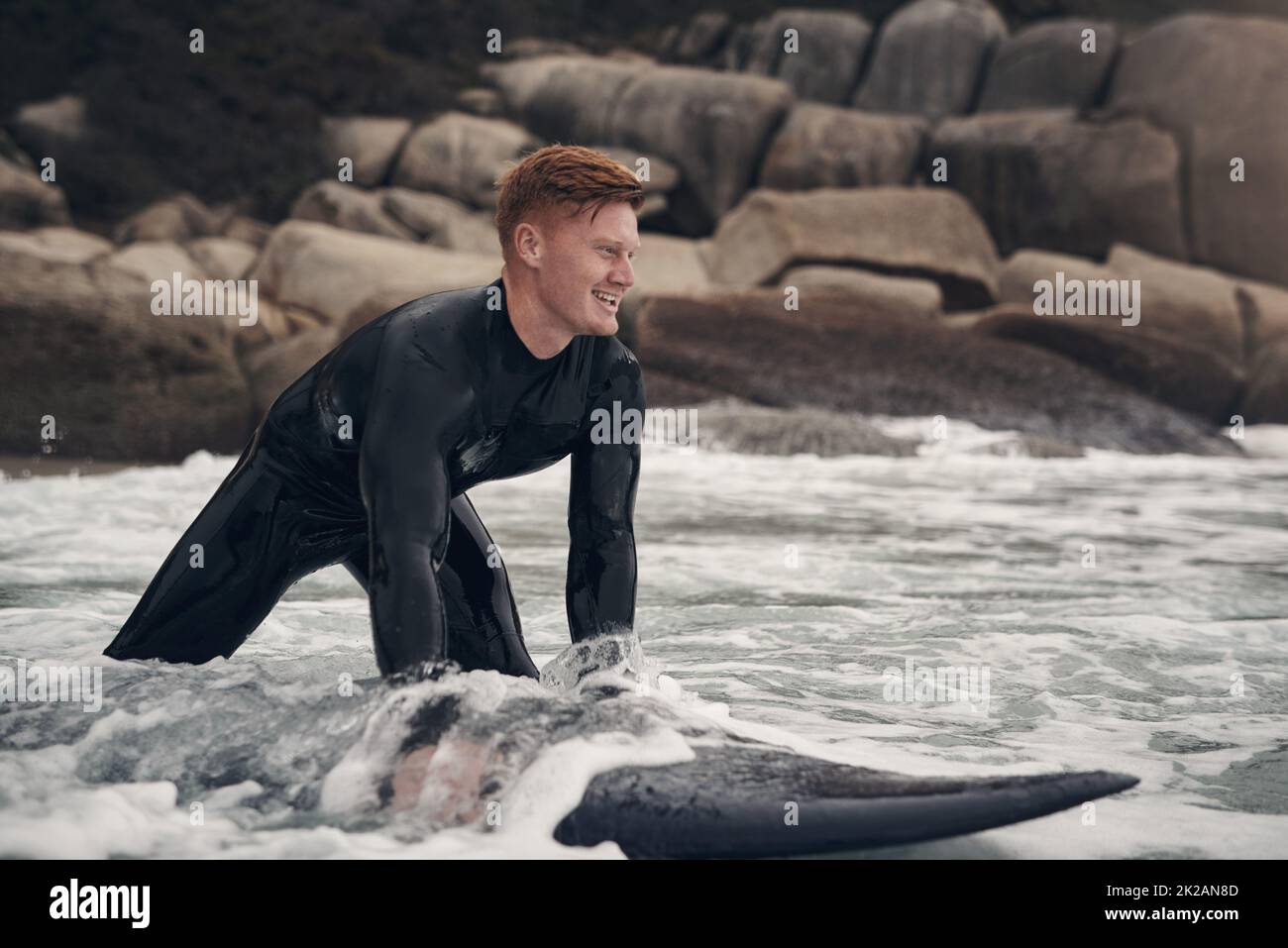 Surfen ist wie nichts anderes auf der Welt. Aufnahme eines jungen Mannes, der am Strand surft. Stockfoto