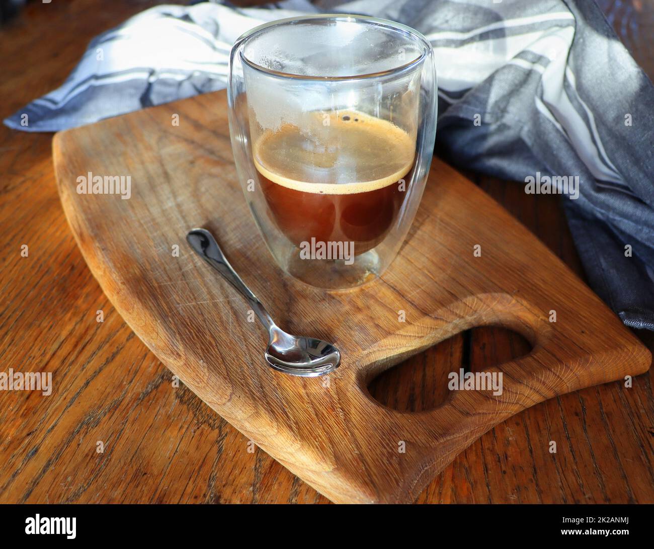 Transparenter doppelwandiger Glaskrug mit Espresso-Kaffee auf rustikalem Holzhintergrund Stockfoto