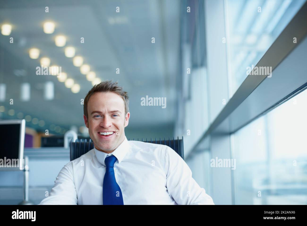 Lächelnde männliche Führungskräfte. Porträt eines hübschen männlichen Executive, der auf einem Bürostuhl sitzt. Stockfoto