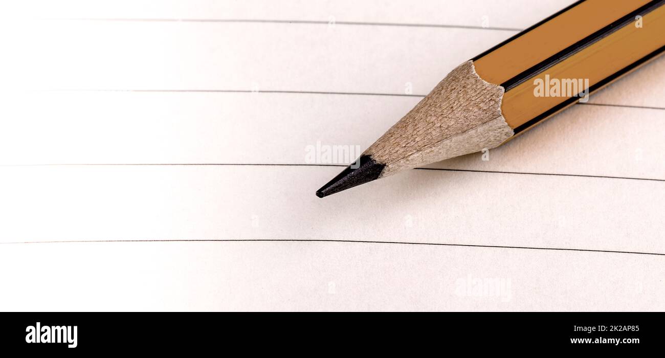 Bleistiftspitze auf weiß liniertem Papier. Selektiver Fokus Stockfoto