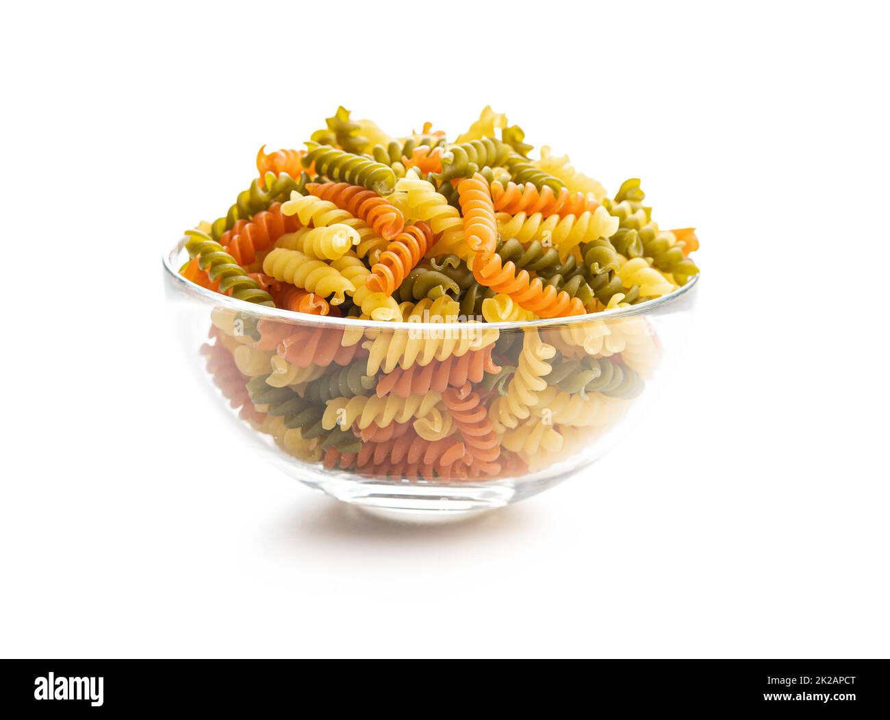 Dreifarbige Fusilli-Pasta in der Schüssel. Bunte italienische rohe Pasta, isoliert auf weißem Hintergrund. Stockfoto