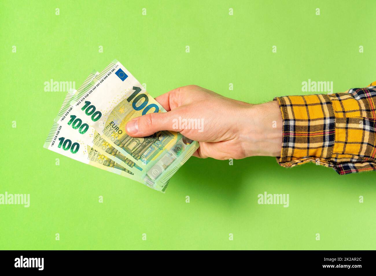 Hand hält Euro-Banknoten auf grünem Hintergrund Stockfoto
