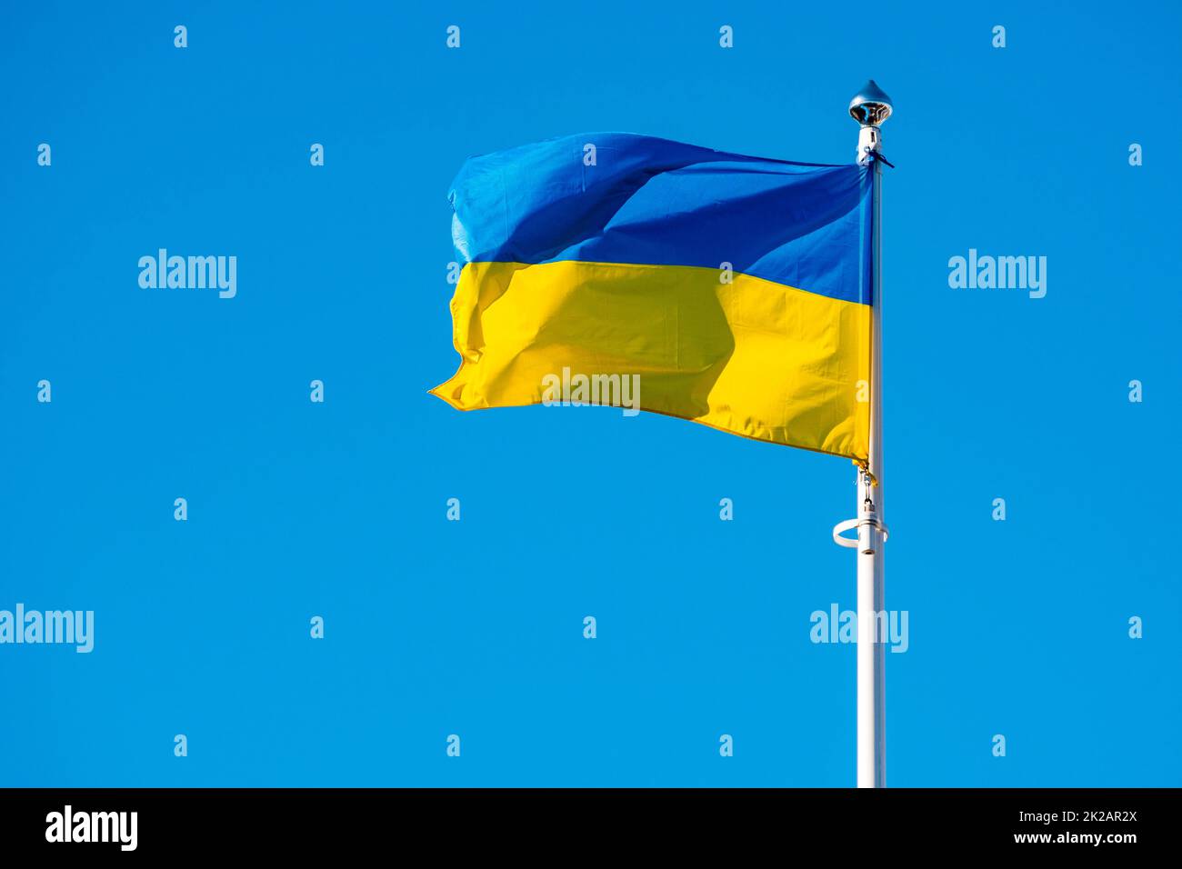 Flagge der Ukraine vor dem Hintergrund eines strahlend blauen Himmels Stockfoto