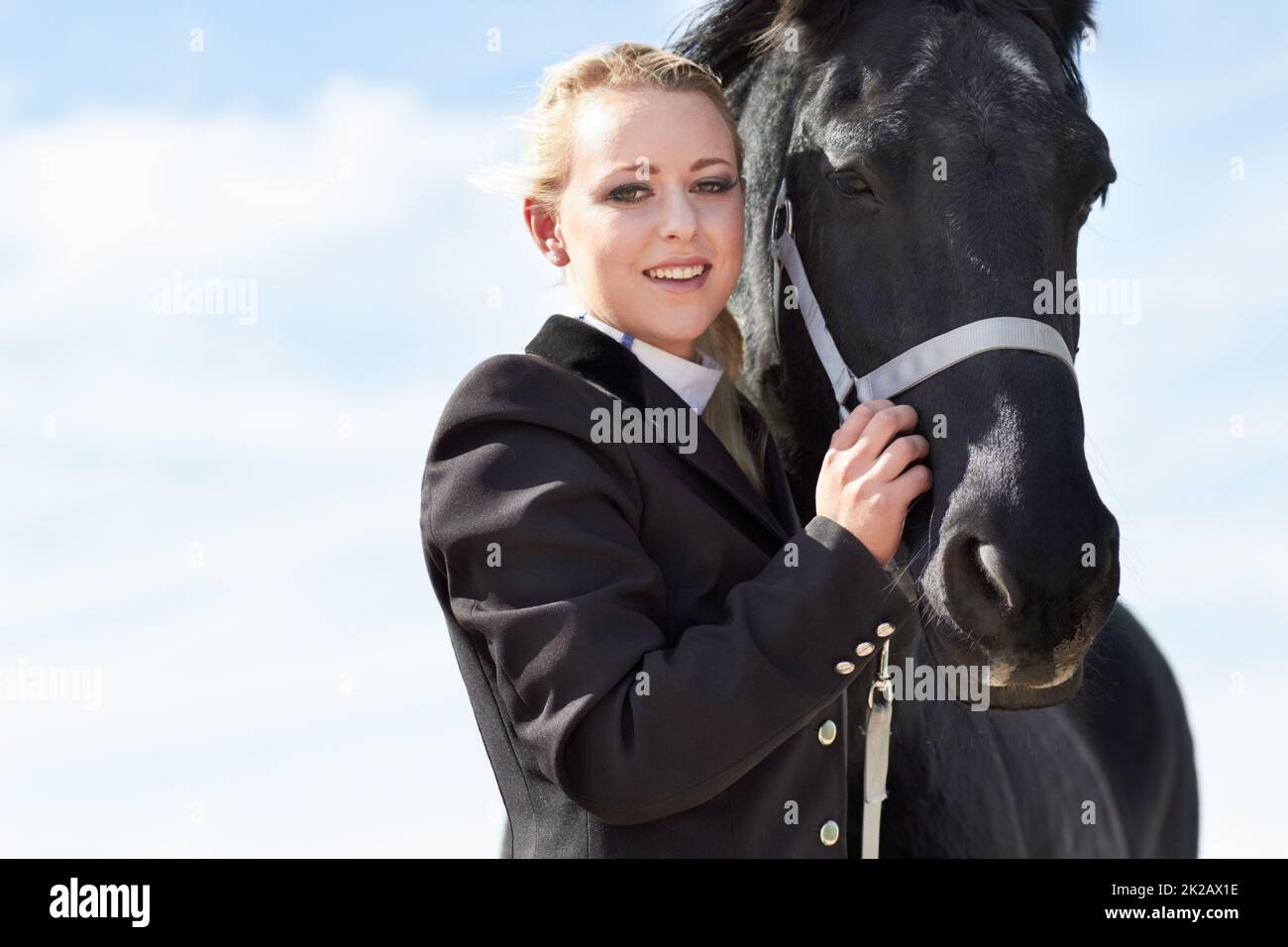 Die Verbindung zwischen Reiter und Pferd. Porträt einer jungen Reiterin, die ihr Pferd liebevoll umarmt. Stockfoto